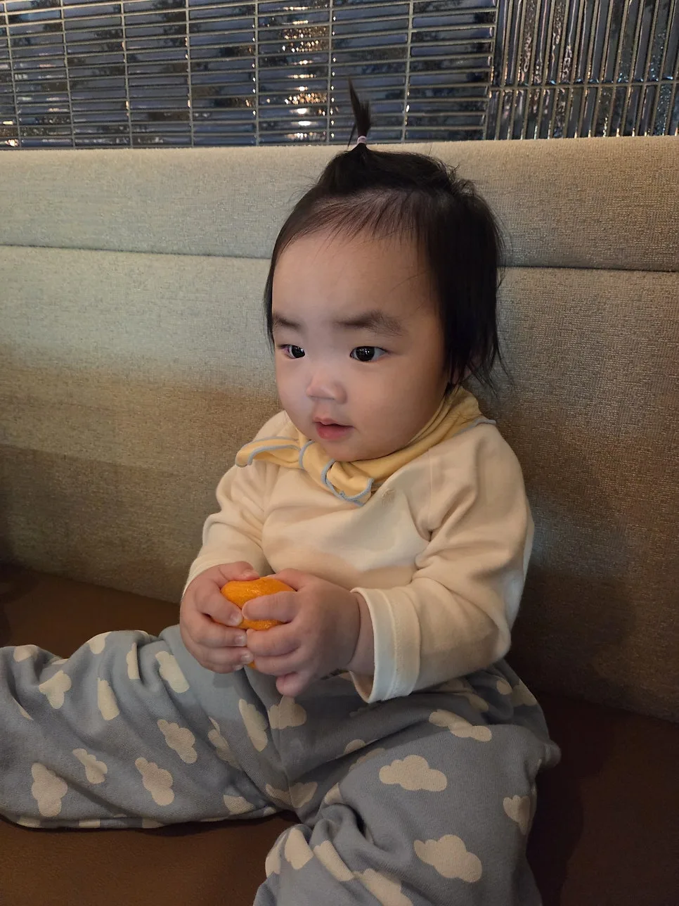baby holding tangerine